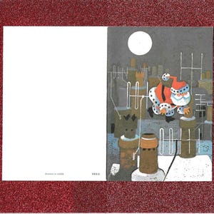 May include: A Christmas card with a red glitter border. The illustration shows Santa Claus on a rooftop under a full moon. The left side of the card is blank. Text at the bottom reads "Printed in USA".