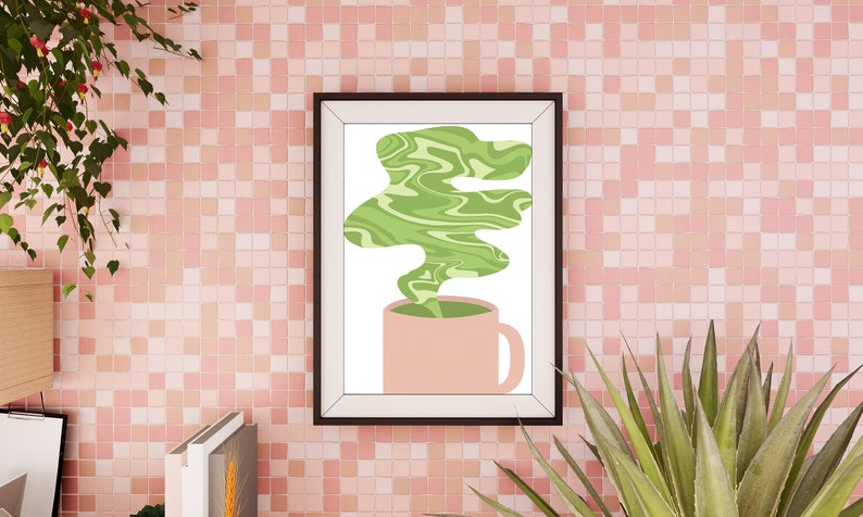 May include: A framed art print featuring a pink mug with green, swirled steam rising from it. The artwork is set against a pink tiled wall, with plants in the foreground and background.