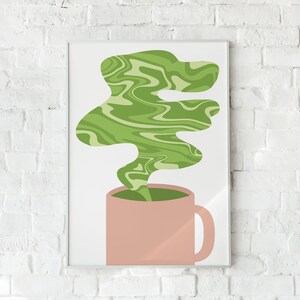 May include: A framed art print featuring a pink mug with green liquid and a swirling green vapor design. The artwork is set against a white background and a white brick wall.