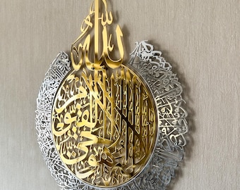 Op de afbeelding: Een wanddecoratie van goud en zilver metaal met islamitische kalligrafie. Het midden van de kunst toont het woord "Allah" in goud, omringd door een cirkel van zilveren Arabische schrift.