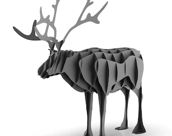 Puede incluir: Una escultura de reno gris estilizada con grandes cuernos. La escultura está hecha de piezas curvas y superpuestas, lo que le da un aspecto moderno y geométrico. El reno se alza sobre cuatro delgadas patas sobre un fondo blanco.