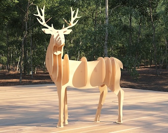 Puede incluir: Una escultura de ciervo de madera hecha de madera contrachapada en capas. El ciervo está de pie sobre una superficie de madera.