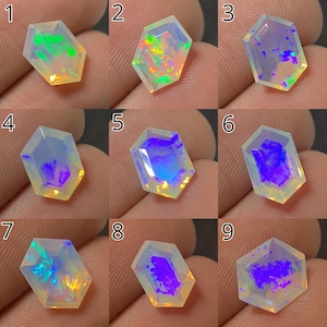 May include: A collection of nine faceted opal gemstones, each with a unique play of color. The opals display a range of hues, including green, orange, blue, and purple, within a clear or milky base. The gemstones are cut into a hexagonal shape.
