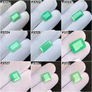 May include: Nine green gemstones with various rectangular and square cuts are displayed on a white surface. The gemstones have a polished, translucent appearance, and are labeled with the numbers P3721 to P3729.