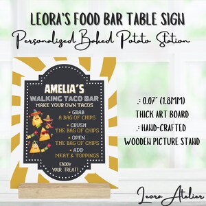 Può includere: Un cartello in ardesia nera con il testo "Amelia's Walking Taco Bar Make Your Own Tacos" e istruzioni per assemblare un taco. Il cartello è su un supporto in legno e ha uno sfondo bianco e dorato. Il cartello è spesso 1,8 mm ed è fatto di cartone per l'arte.