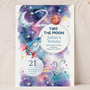 Puede incluir: Una tarjeta de invitación de cumpleaños rectangular con un tema espacial en acuarela, que incluye un cohete azul, una luna creciente sonriente y un planeta. El texto dice: TWO THE MOON, Julian's Birthday, 4054 South Ocean Parkway, Miami FL 33456, 21, SATURDAY OCTOBER AT 3PM.
