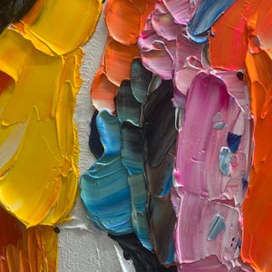 K&ouml;nnte beinhalten: Nahaufnahme eines abstrakten &Ouml;lgem&auml;ldes mit dicken Pinselstrichen. Das Kunstwerk zeigt eine lebendige Farbpalette, darunter Gelb, Orange, Rosa, Blau und Gr&uuml;n, aufgetragen auf eine wei&szlig;e Leinwand. Die Textur ist stark pastos und erzeugt einen dreidimensionalen Effekt.