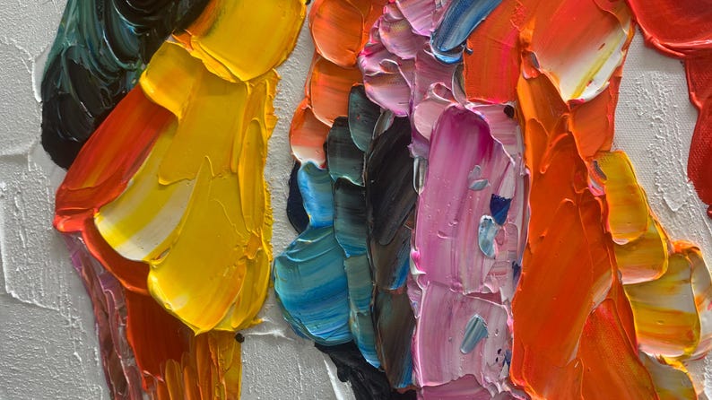 K&ouml;nnte beinhalten: Nahaufnahme eines abstrakten &Ouml;lgem&auml;ldes mit dicken Pinselstrichen. Das Kunstwerk zeigt eine lebendige Farbpalette, darunter Gelb, Orange, Rosa, Blau und Gr&uuml;n, aufgetragen auf eine wei&szlig;e Leinwand. Die Textur ist stark pastos und erzeugt einen dreidimensionalen Effekt.