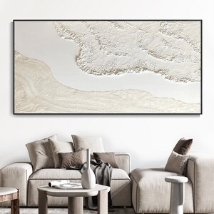 May include: Abstract art print with a white and cream color scheme. The print features a textured, layered design that resembles waves or clouds.