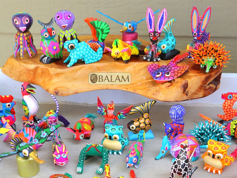 May include: A collection of colorful, hand-painted wooden animal figurines. The figurines are arranged on a wooden surface and include a variety of animals, such as a rooster, a squirrel, a rabbit, a frog, and a fish. The figurines are all brightly colored and feature intricate details.