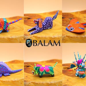 May include: Six colorful wooden animal figurines, including an armadillo, a dog, a fish, a lizard, a bull, and a dragon. The figurines are painted in bright colors and have intricate details. The figurines are arranged on a wooden surface. The word "BALAM" is printed in the center of the image.