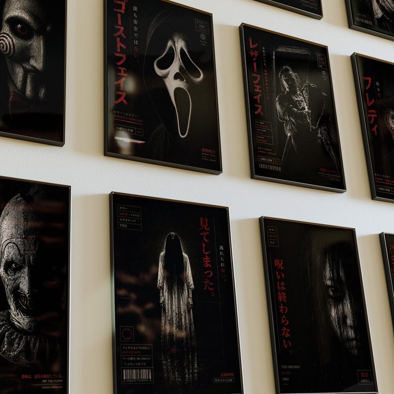Puede incluir: Una colecci&oacute;n de carteles enmarcados de pel&iacute;culas de terror, cada uno con un personaje o escena diferente. Los carteles son predominantemente en blanco y negro con texto japon&eacute;s rojo. Los personajes incluyen una figura enmascarada, una cara de fantasma y una mujer con cabello negro largo.