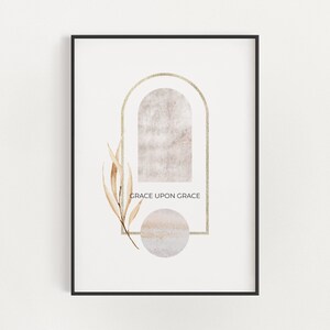 Könnte beinhalten: Ein minimalistischer Kunstdruck mit einem goldenen Torbogen und einem beigefarbenen Kreis auf weißem Hintergrund. Der Text "GRACE UPON GRACE" ist in Schwarz unter dem Torbogen geschrieben.