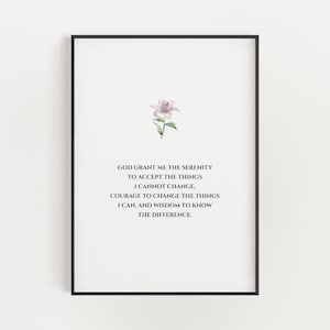 Puede incluir: Una impresión enmarcada con fondo blanco y borde negro. La impresión presenta una ilustración en acuarela de una pequeña flor rosa en la parte superior. Debajo está el texto: "GOD GRANT ME THE SERENITY..." en una fuente simple y elegante.