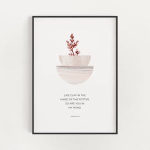 May include: A minimalist art print with a watercolor illustration of a plant in a bowl. The print features the quote "Like clay in the hand of the potter, so are you in my hand." and the scripture reference "Jeremiah 18:6".
