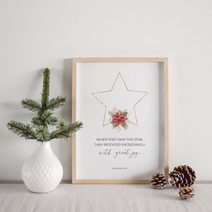 May include: A framed print featuring a gold star and a poinsettia flower. The print includes the text "WHEN THEY SAW THE STAR, THEY REJOICED EXCEEDINGLY with great joy. MATTHEW 210".
