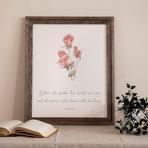 May include: A framed print with a watercolor illustration of pink roses and the text "When she speaks, her words are wise. And she gives instructions with kindness. Proverbs 31:26"