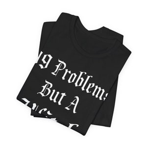 May include: Black t-shirt with white text that reads "No Problems But A Mess". The shirt is folded in half.