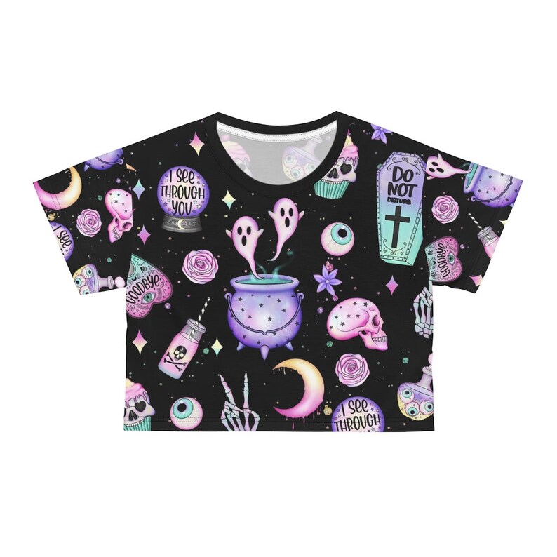 May include: Black crop top with a repeating pattern of whimsical Halloween-themed illustrations. The design includes a crystal ball, ghosts, skulls, potion bottles, and a cauldron. The words "I SEE THROUGH YOU" and "DO NOT DISTURB" are visible.
