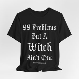May include: Black t-shirt with white text that reads "99 Problems But A Witch Ain't One" and a small logo that reads "Nocturnal Doll".