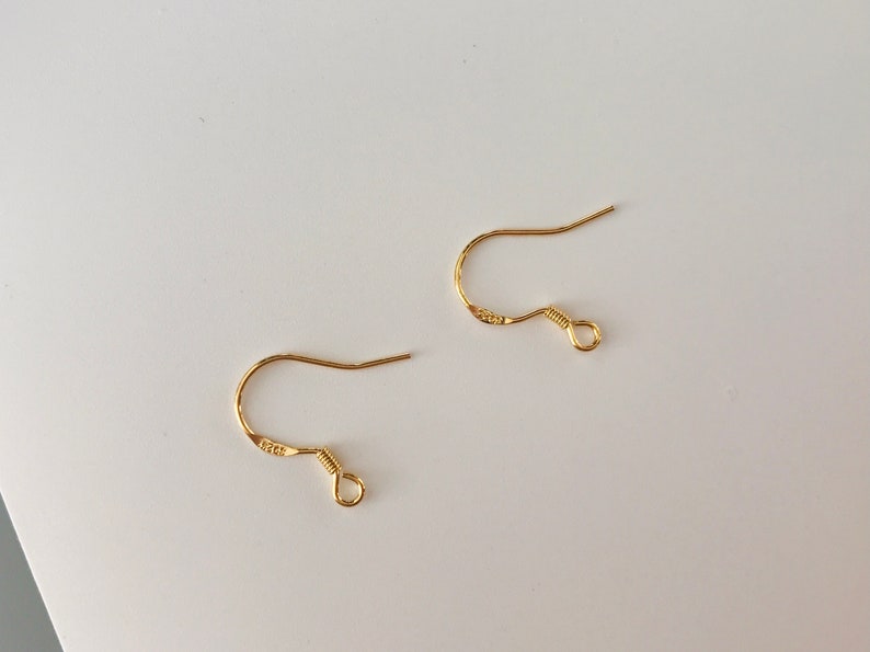 May include: Two gold-toned earring hooks with a small loop at the end.