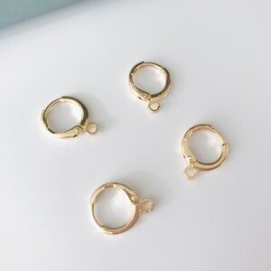 May include: Four gold-toned hoop earrings with a small jump ring attached to each hoop.