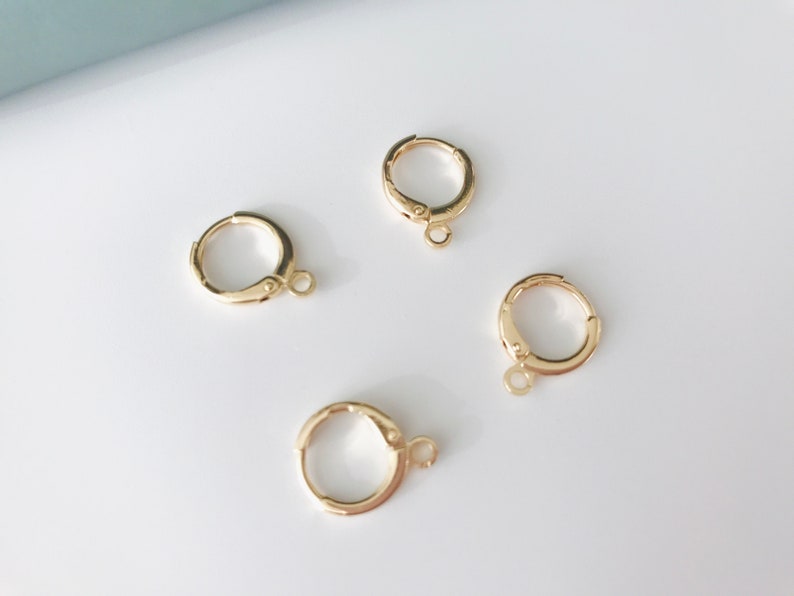 May include: Four gold-toned hoop earrings with a small jump ring attached to each hoop.