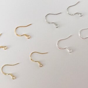 May include: A set of gold and silver earring hooks. The hooks are made of metal and have a simple design. They are perfect for making your own earrings.