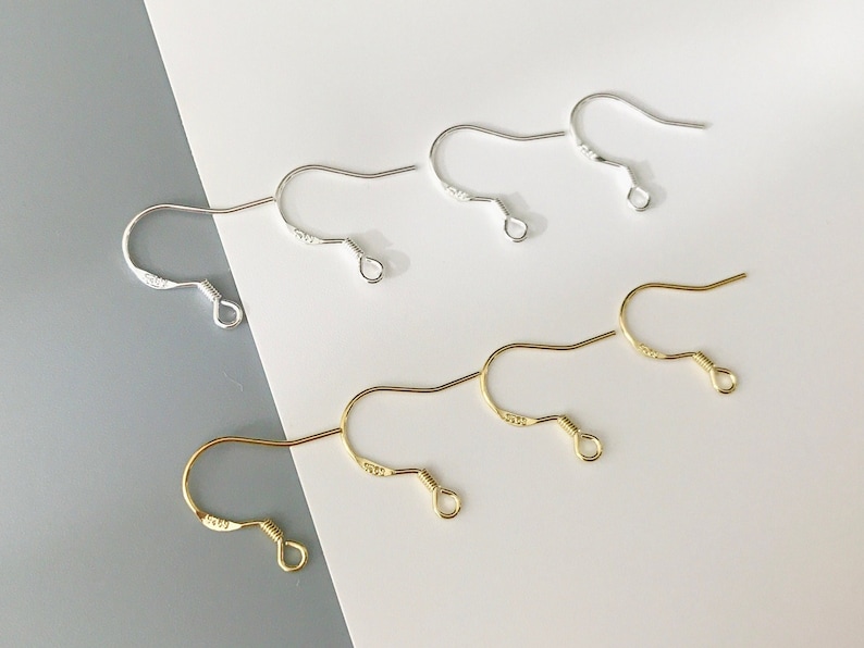 May include: A set of earring hooks in silver and gold. The hooks are made of metal and have a simple design. They are perfect for making your own earrings.