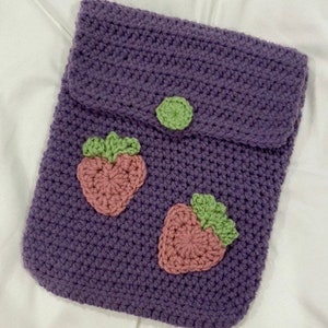 May include: Purple crocheted pouch with a flap closure and two pink and green strawberry appliques.
