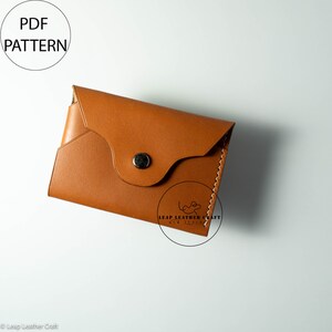 May include: A brown leather wallet with a flap closure and a snap button. The wallet is made by Leap Leather Craft New Zealand.