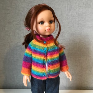 K&ouml;nnte beinhalten: Eine Puppe tr&auml;gt eine gestreifte Strickjacke in Regenbogenfarben mit drei blauen Kn&ouml;pfen. Die Puppe hat rotes Haar, Sommersprossen und tr&auml;gt eine blaue Jeans. Die Strickjacke hat horizontale Streifen in verschiedenen Farben.