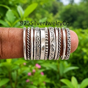 May include: A set of ten silver rings featuring various textures and patterns, including twisted rope, geometric shapes, floral engravings, and smooth bands. The text 925SilverJewelryCo is visible at the top of the image above the rings.