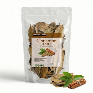Op de afbeelding: Een doorzichtige plastic stazak gevuld met gedroogde bruine kaneelbladeren. Het etiket bevat de tekst Natural Lanka, Cinnamon LEAVES en een afbeelding van groene bladeren en kaneelstokjes. Een hoopje bladeren en kaneelstokjes ligt eronder.