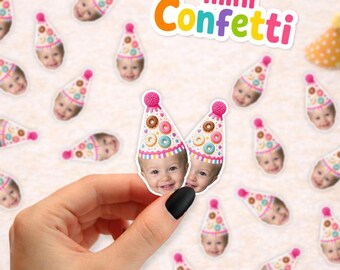 May include: Customized paper confetti pieces featuring a photograph of a child wearing a party hat decorated with colorful donut illustrations. The confetti is scattered across a surface, with the text mini Confetti visible at the top right.