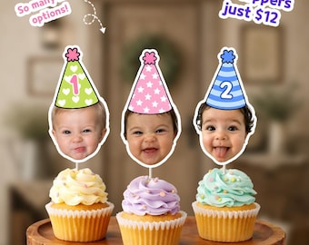 May include: Three cupcakes topped with custom face cutouts wearing party hats. The hats are green with hearts and the number 1, pink with stars, and blue with stripes and the number 2. Text reads: So many hat options! 24 toppers just $12.