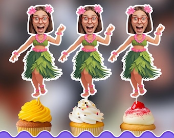 May include: Three personalized cupcake toppers featuring a cartoon illustration of a person with brown hair and red glasses wearing a green grass skirt, a pink flower lei, and pink flower hair accessories, each standing atop a different cupcake.