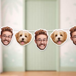 Può includere: Ghirlanda decorativa con immagini ritagliate di un uomo e un cane. L'uomo ha capelli castani ricci, occhiali e un'espressione sorridente. Il cane è marrone chiaro con la lingua di fuori.