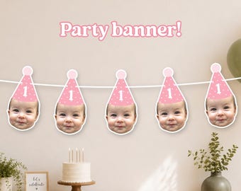 May include: A party banner featuring five cutouts of a baby's face, each wearing a pink party hat with white polka dots and the number one. The text Party banner! is displayed above the banner, which is strung on a white cord.