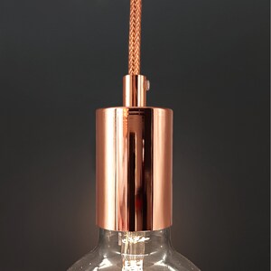 Peut inclure: Un luminaire en cuivre avec un cordon tressé et un abat-jour cylindrique.
