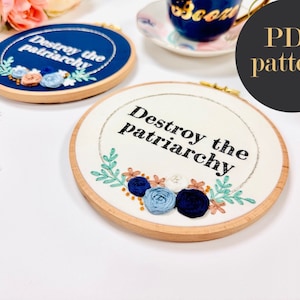Peut inclure: Deux motifs de broderie en cercle avec le texte "Destroy the patriarchy" et des motifs floraux en bleu, vert et blanc.