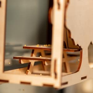 Peut inclure: Mod&egrave;le en bois d'une table de pique-nique et d'un arbre, avec une finition en bois clair. La table a deux bancs et l'arbre a une forme simple et arrondie.