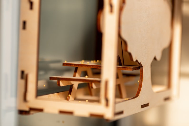 Peut inclure: Mod&egrave;le en bois d'une table de pique-nique et d'un arbre, avec une finition en bois clair. La table a deux bancs et l'arbre a une forme simple et arrondie.
