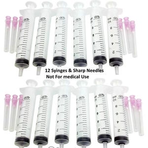 May include: A set of 12 clear plastic 10 ml syringes with black rubber plungers and separate sharp needles with pink caps. The text 12 Syringes & Sharp Needles Not For medical Use is printed in black in the center of the image.