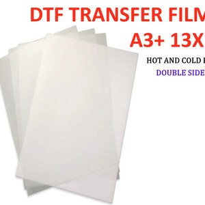 Pode incluir: Uma pilha de folhas de filme de transfer&ecirc;ncia DTF brancas no tamanho A3+ (13x19 polegadas). O filme &eacute; de dupla face e pode ser descascado a quente ou a frio.