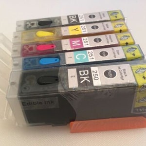 May include: A set of six ink cartridges for a printer. The cartridges are black, cyan, magenta, yellow, and two black cartridges. The cartridges are labeled with the ink color and the cartridge number. The cartridges are in a clear plastic case with a orange base.