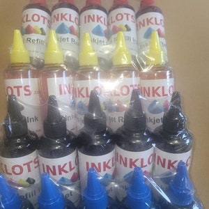May include: A close-up of a package of 12 ink bottles for inkjet printers. The bottles are arranged in three rows of four, with the labels facing the camera. The bottles are labeled "INKLOT" and "Refill Inkjet".