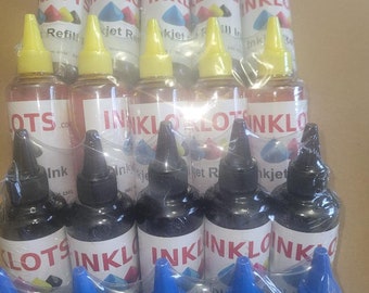 Peut inclure: Gros plan sur un paquet de 12 bouteilles d'encre pour imprimantes à jet d'encre. Les bouteilles sont disposées en trois rangées de quatre, les étiquettes étant tournées vers l'appareil photo. Les bouteilles sont étiquetées "INKLOT" et "Recharge Jet d'encre".