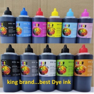 May include: Ten bottles of dye ink for printers. The bottles are labeled "Dye Ink" and have a variety of colors, including black, cyan, magenta, yellow, and red. The bottles are arranged in two rows of five.