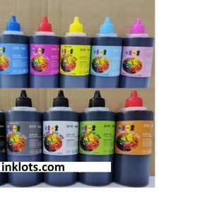May include: A collection of dye ink bottles with various colored caps, including black, blue, red, yellow, and pink. Each bottle has a label with the text "DYE INK" and a colorful graphic. The website inklots.com is visible on the labels.